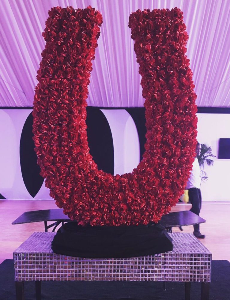 A large red flower arrangement on top of a platform.
